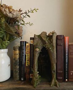 there is a vase with flowers and books on the shelf next to some bookshelves