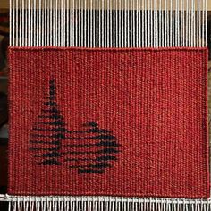 a close up of a weaving machine with red and black material on it's side