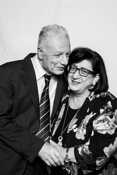 an older man and woman are hugging each other