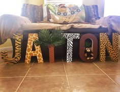 the letters are made out of wood and decorated with animal prints, palm trees, and zebras