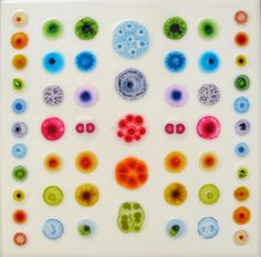 a white plate topped with lots of different colored glass pieces on top of it's surface