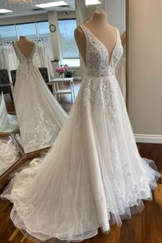 a wedding dress on display in front of a mirror