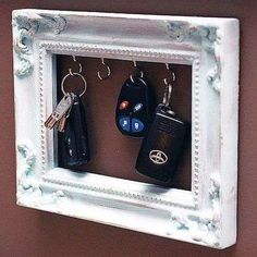 a white frame with two keys hanging on it