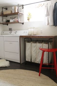 a washer and dryer sitting in a room next to a table with two chairs