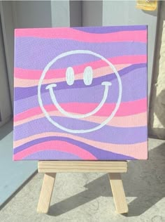 a small canvas with a smiley face painted on it