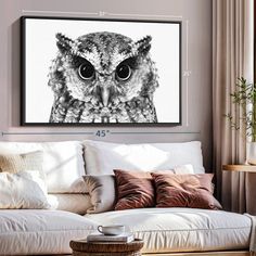 an owl's eyes are shown on the wall above a couch in a living room