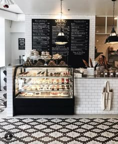 the interior of a coffee shop with black and white tiles