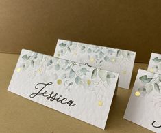 three place cards with leaves and dots on them