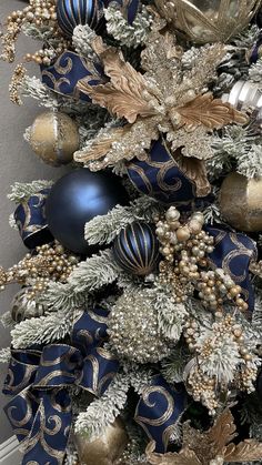 a blue and gold christmas tree with ornaments