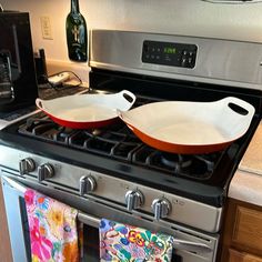 two pans are sitting on top of an oven