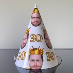 a party hat with the faces of two men wearing crowns