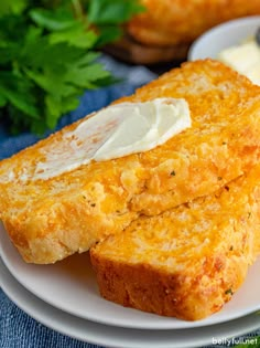 two pieces of bread on a plate with butter and parsley