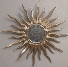 a metal sunburst mounted to the side of a wall