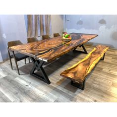 a wooden table with two benches next to it on top of a hard wood floor