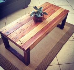 a wooden table with a potted plant sitting on it's top in front of a couch