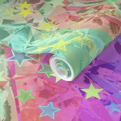 a colorful wallpaper with stars on it and a roll of paper in the middle