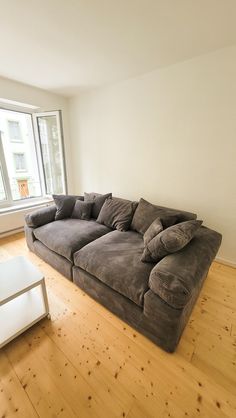 a large couch sitting on top of a hard wood floor