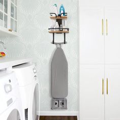 a washer and dryer in a room with wall paper on the walls behind them