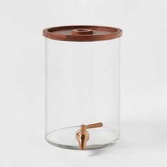 a glass jar with a wooden lid and a small metal object in the bottom half