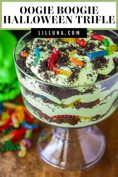 a halloween trifle in a glass dish on a wooden table with the title above it