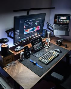 a desk with two laptops and a desktop computer on it, all lit up