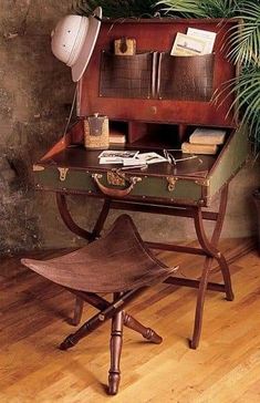 an old fashioned desk with a lamp and potted plant next to it on a hard wood floor