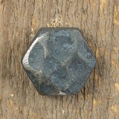 a rock sitting on the side of a tree trunk next to a piece of wood