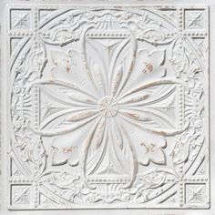 a white ceiling tile with an intricate design on the center and bottom part of it