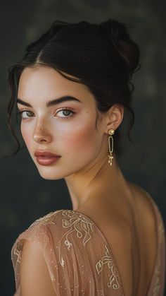 a woman with blue eyes wearing gold earrings