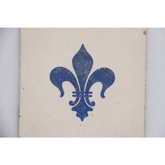 a blue and white tile with a fleur de lis design on the side