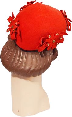 A darling 1940s true vintage bright red felt with a hint of orange small calot or beanie look hat with felt flowers, bows and gold studs.A few flaws. See below.I love this unique hat. The shape is modified beanie that tapers in the back and is meant to sit slightly toward the back of the head. It is deep orangey red felt with bows topped by felt flowers that are studded with gold metal studsIt is unlined with a narrow peach hat band inside.Structurally very good but it does have unfortunate moth dots. The most evident are 2 tiny ones on the top. I have shown a photo of the damage.The underside has more but they aren't seen when worn.A piece of matching felt could be added underneath to cover the holes. Priced accordingly.Still a very fun wearable unique vintage 1940s hat. 1940s Hats, Back Of The Head, Unique Hats, Vintage 40s, Red Felt, 1940s Fashion, Hat Band, Felt Flowers, Hat Shop