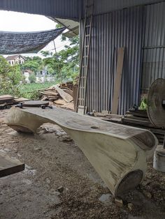 a wooden bench sitting on top of a pile of dirt next to a building with windows