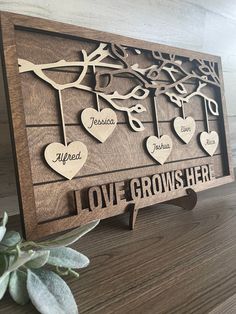 a wooden plaque with the names and hearts on it