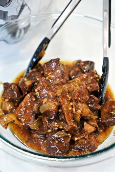 a glass bowl filled with meat and sauce