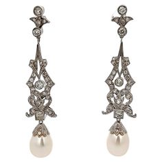 Pearl and Diamond Earrings Earrings set with round cut diamonds, and two cultured pearls elegantly dangling. Measurements: 2.5" long Back Type: push back Metal Type: 18-karat white gold Luxury Platinum Pearl Earrings For Formal Occasions, Elegant Platinum Drop Bridal Earrings, Elegant Platinum Earrings For Evening, Elegant Platinum Bridal Drop Earrings, Elegant Evening Platinum Earrings, Classic White Gold Pearl Earrings, Classic Platinum Pearl Earrings For Formal Occasions, Elegant Platinum Dangle Bridal Earrings, Classic Silver Platinum Pearl Earrings