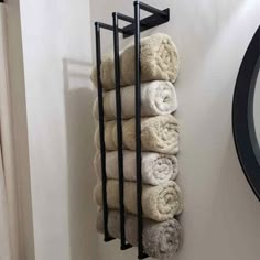 a towel rack is hanging on the wall next to a mirror with towels in it