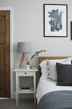 a bedroom with a bed, nightstand and pictures on the wall