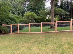 a wooden fence is in the middle of a grassy area