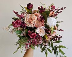 a vase filled with lots of flowers on top of a table