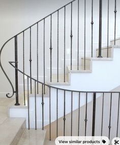 a white staircase with black railing and handrails