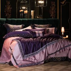 a bed with purple comforter and pillows in a dark room next to a mirror