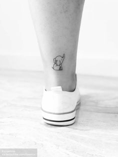 a small tattoo on the ankle of a woman's foot, with an elephant