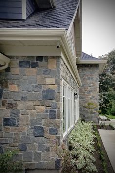 a stone house with white trim and windows