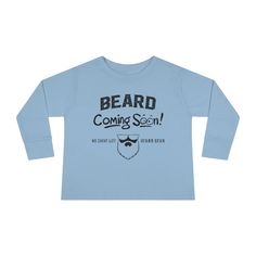 The Beard Coming Soon Toddler Long Sleeve Shirt is one of the newest shirts in our collection. The new Beard Coming Soon Toddler Long Sleeve Shirt is the perfect long sleeve for the cold season. Designed to bring the best to the youngest of us all, it is made stylish, comfortable, and easy to put on. The ideal long sleeve for little ones, with high-quality fabric that feels like a gentle hug. 100% combed ringspun cotton Light fabric Toddler unisex fit Neck and shoulder tape prevents stretching S Winter Long Sleeve Graphic Shirt, Basic Blue Long Sleeve T-shirt, Blue Long Sleeve Basic T-shirt, Blue Relaxed Fit Shirt For Winter, Trendy Blue Long Sleeve Tops, Relaxed Fit Long Sleeve Winter Shirt, Trendy Blue Winter Shirt, Basic Blue Tops For Winter, Trendy Blue Long Sleeve T-shirt