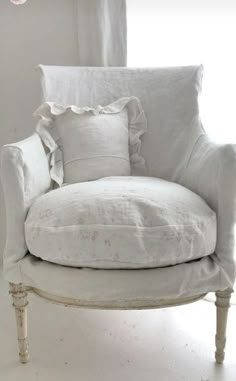 a white chair with some pillows on it