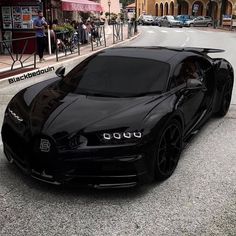 a black bugatti is parked on the street