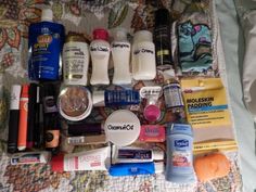 an assortment of personal care products laid out on a bed with the covers pulled back