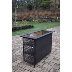 an outdoor table with a glass top and metal frame on the outside brick patio area