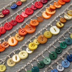 many different colored buttons are hanging from chains