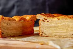 a pastry cut in half sitting on top of a cutting board next to another piece of bread